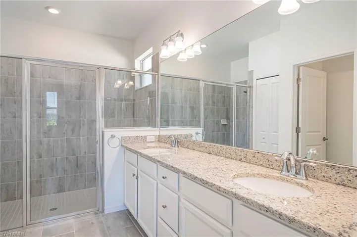 Bathroom with tile patterned floors, vanity, and an enclosed shower