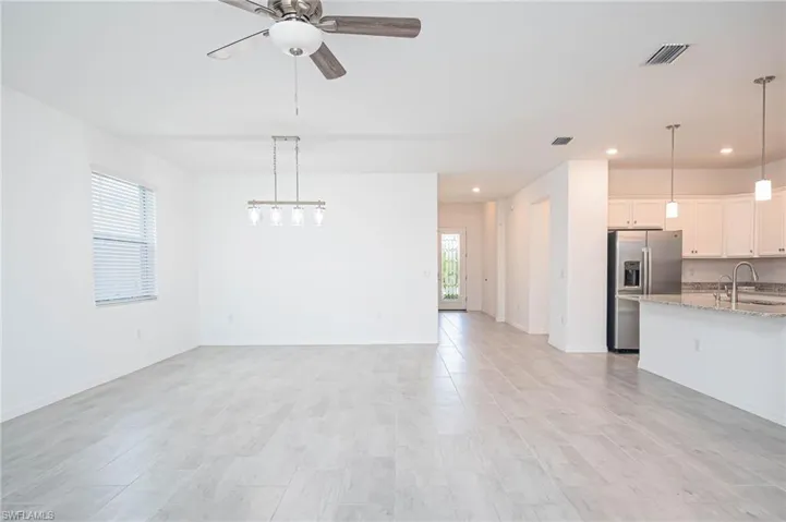 Unfurnished living room featuring ceiling fan, sink, a healthy amount of sunlight, and light hardwood / wood-style flooring