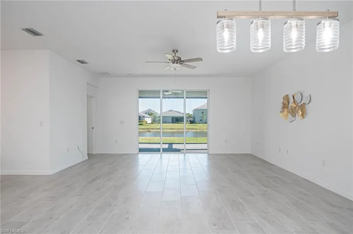 Empty room with ceiling fan, light hardwood / wood-style floors, and a water view