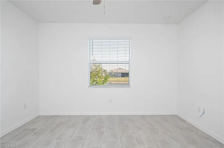 Empty room with ceiling fan and light wood-type flooring
