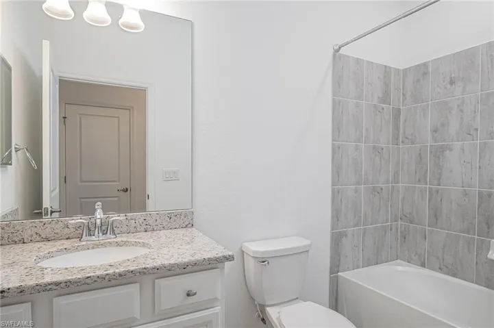 Full bathroom featuring toilet, vanity, and washtub / shower combination