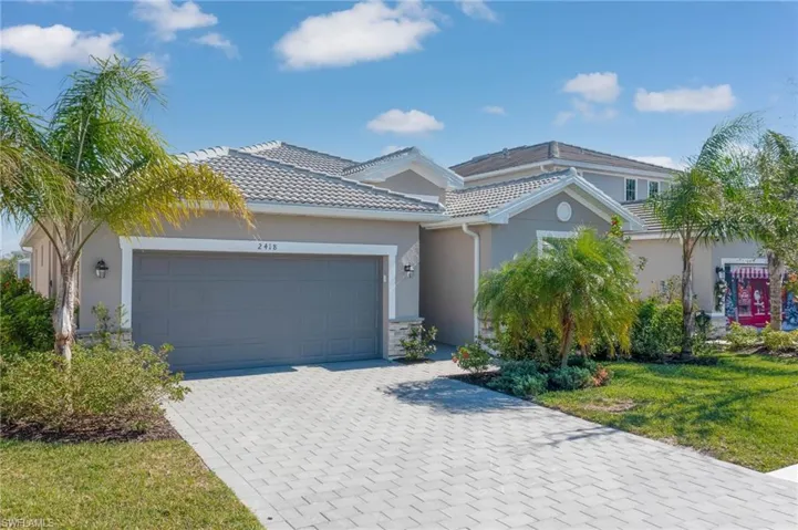View of front of house featuring a front lawn and a garage