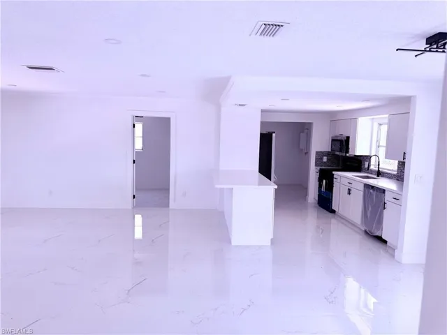 Kitchen featuring light countertops, visible vents, a sink, and appliances with stainless steel finishes