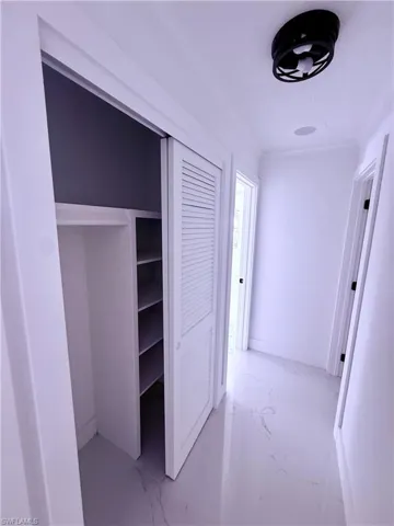 Hall featuring marble finish floor and ornamental molding