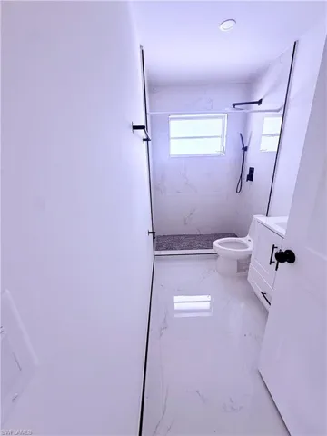 Full bath featuring marble finish floor, vanity, a marble finish shower, and toilet