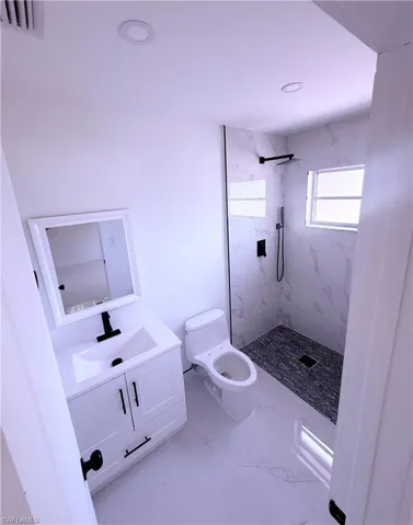 Full bathroom with marble finish floor, visible vents, toilet, vanity, and a marble finish shower