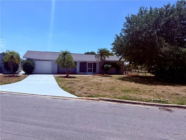 Single story home with driveway, fence, a front yard, and a garage