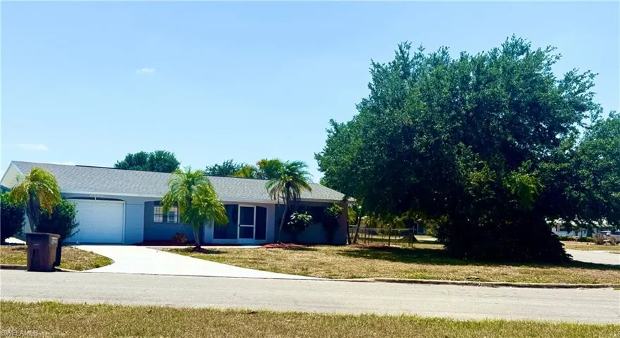 Single story home featuring an attached garage, a front lawn, fence, and concrete driveway