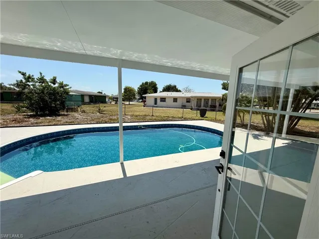 Outdoor pool featuring fence and a patio area