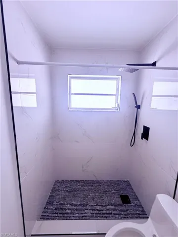 Full bathroom with toilet and a stall shower