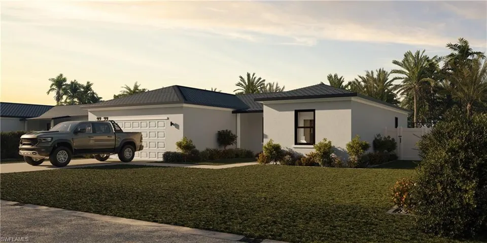 View of front of home with a yard and a garage
