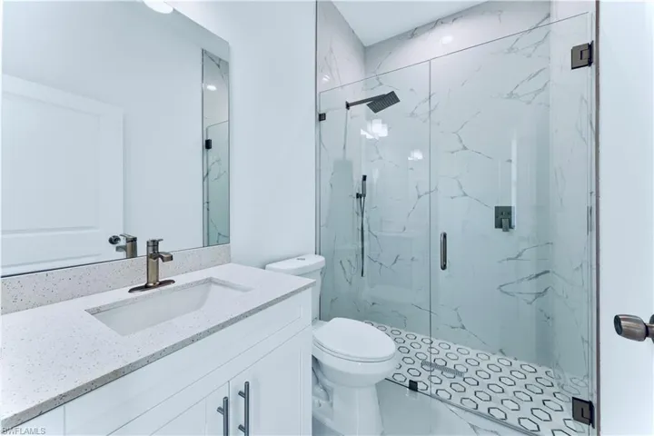 Bathroom with vanity, toilet, and a shower with door