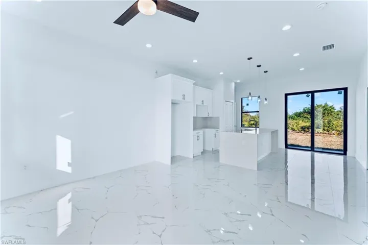Unfurnished living room featuring ceiling fan