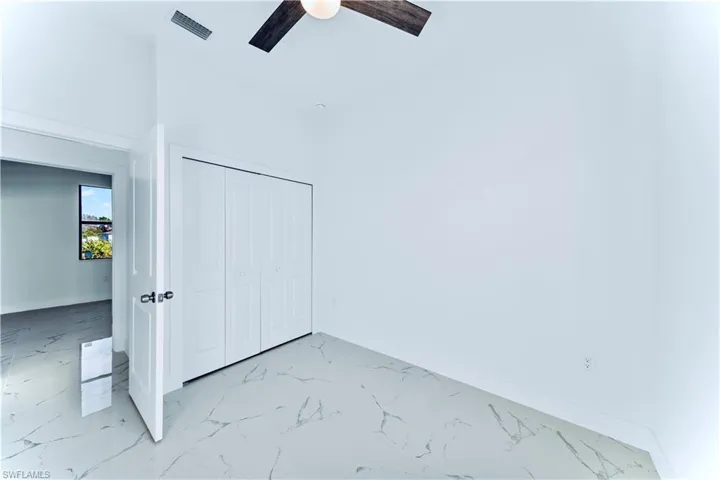 Unfurnished bedroom with ceiling fan and a closet