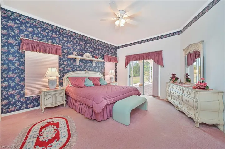 Carpeted bedroom featuring a ceiling fan, ornamental molding, access to exterior, and wallpapered walls