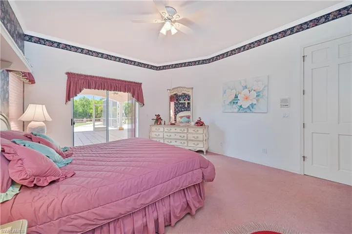 Carpeted bedroom featuring access to exterior and a ceiling fan