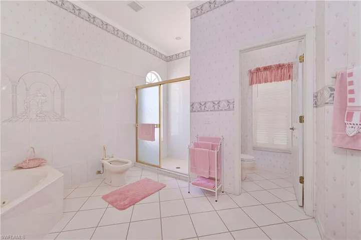 Full bath featuring toilet, visible vents, wallpapered walls, tile patterned flooring, and a shower stall