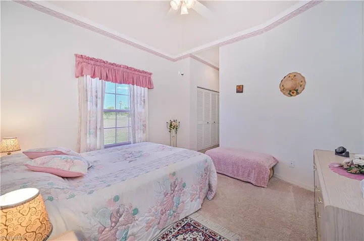 Bedroom featuring a ceiling fan, carpet floors, a closet, crown molding, and baseboards
