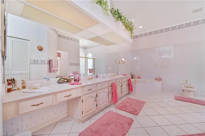 Full bathroom with a bath, tile patterned floors, a bidet, wallpapered walls, and vanity