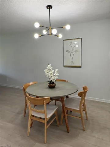 Dining room featuring a textured ceiling, hanging lights, and light wood-type flooring