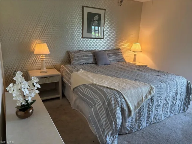 Carpeted bedroom with wallpapered walls