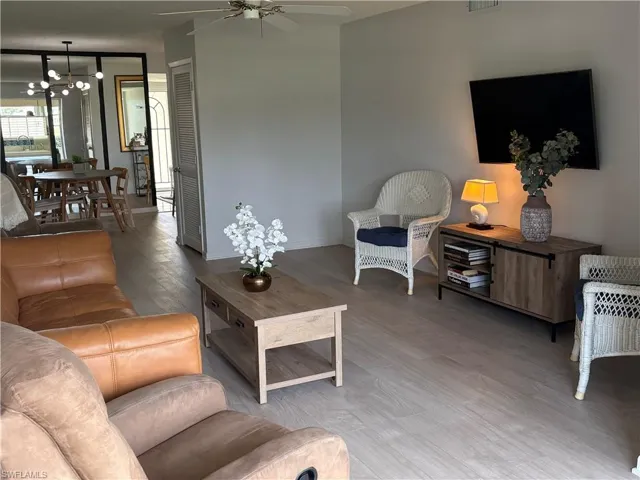 Living area with suspended lighting, wood finished floors, and a ceiling fan