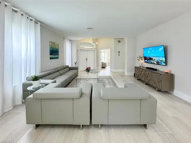 Living room featuring light wood-style floors and a chandelier