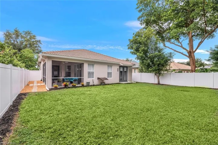 Back of house featuring a fenced backyard, a tiled roof, and stucco siding
