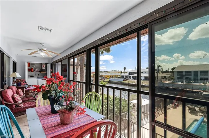 Sunroom with a water view, tile patterned flooring, washer and dryer, and a residential view