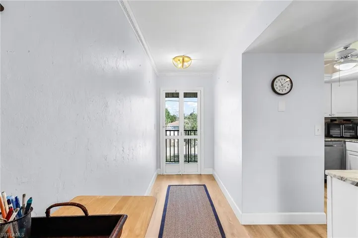 Entryway featuring crown molding, wood finished floors, ceiling fan, and a textured wall