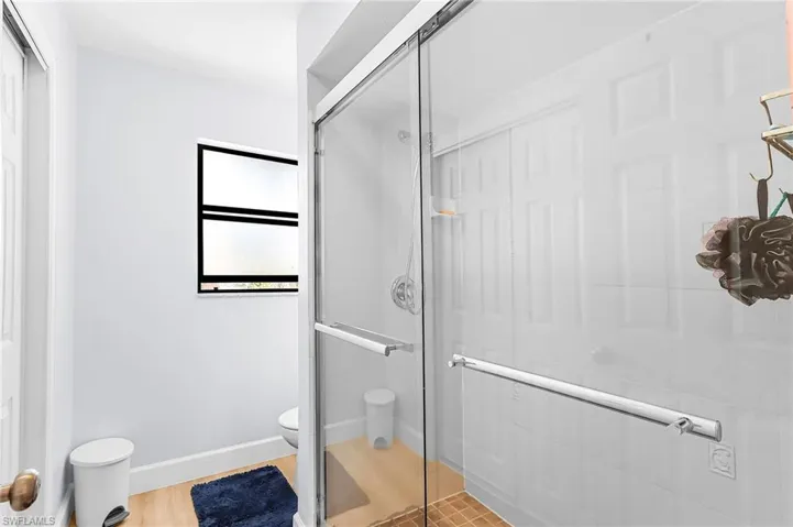 Bathroom featuring a shower stall and light wood-style flooring