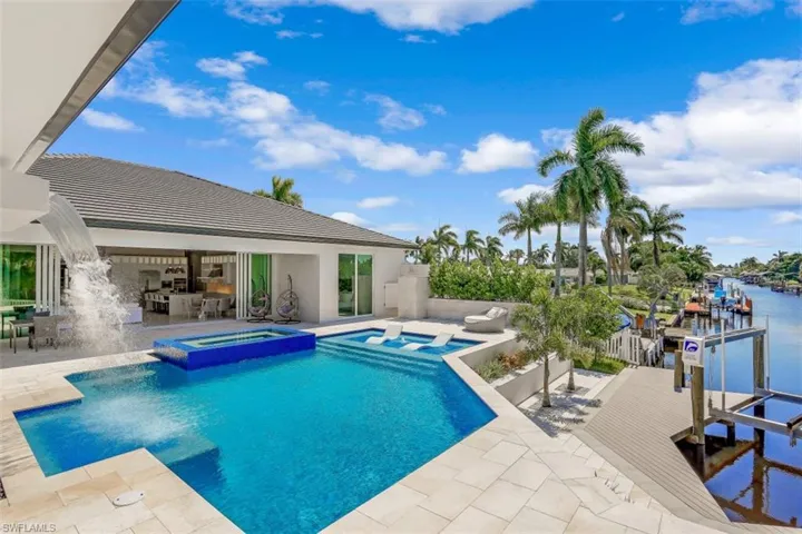 View of pool with a patio, a pool with connected hot tub, and a water view