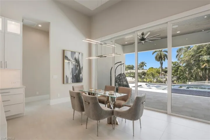 Dining room featuring a ceiling fan, recessed lighting, a towering ceiling, light tile patterned floors, and baseboards