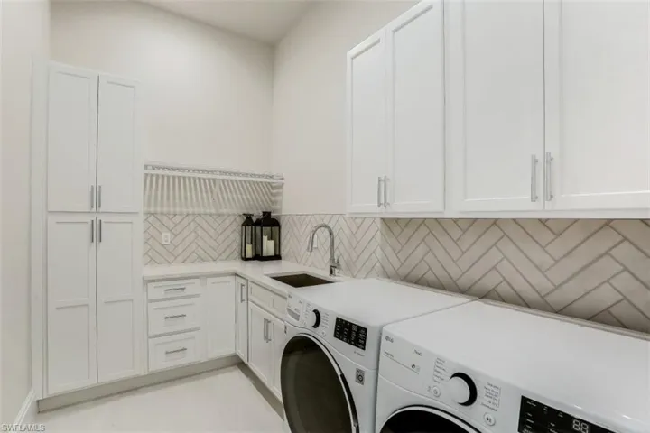 Washroom featuring washer and dryer and cabinet space