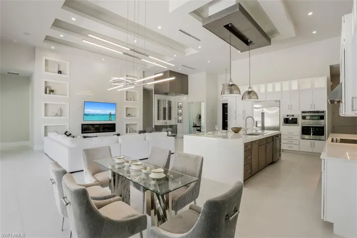 Dining area with a towering ceiling, a chandelier, and recessed lighting