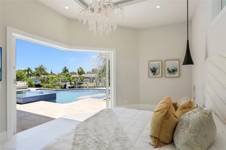 Bedroom featuring access to exterior and a chandelier
