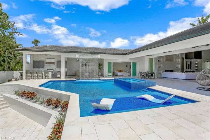 View of swimming pool with a patio, an outdoor bar, and a pool with connected hot tub