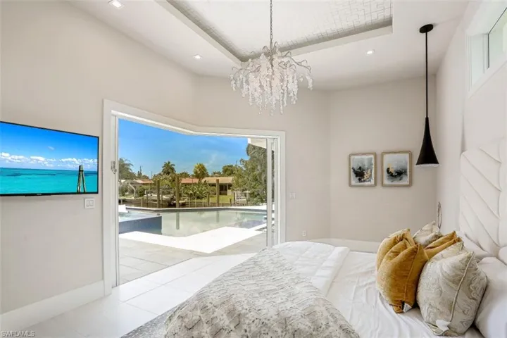 Tiled bedroom with access to exterior, a chandelier, and recessed lighting