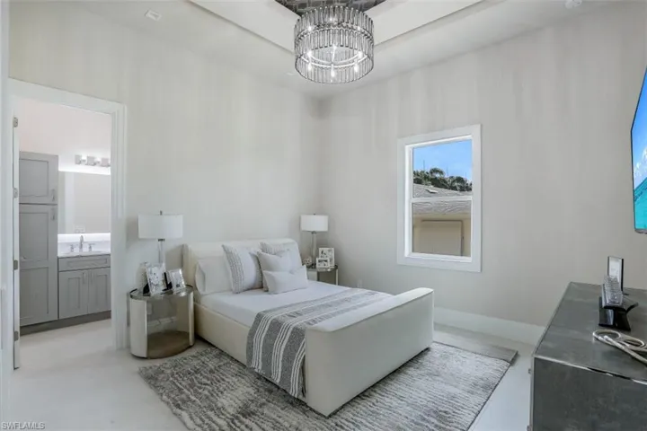 Bedroom with a chandelier, a sink, and ensuite bath