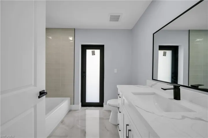 Bathroom featuring vanity and light marble finish flooring