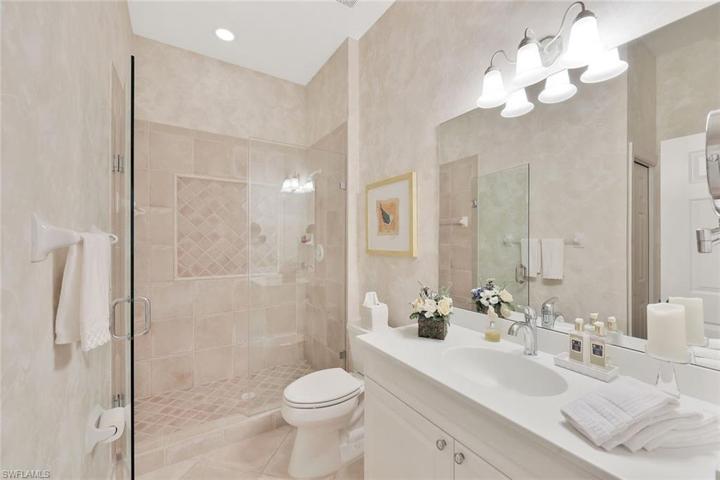 Guest Bathroom with Corian countertops and frameless glass shower.