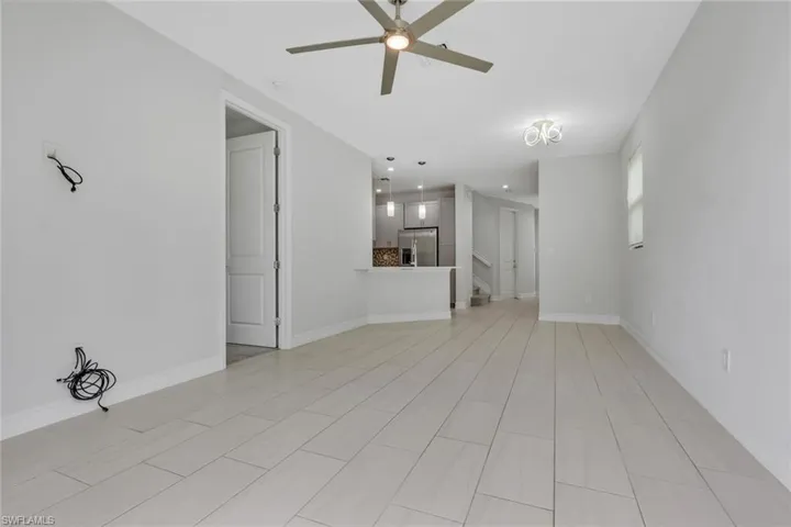 Unfurnished living room with baseboards and a ceiling fan