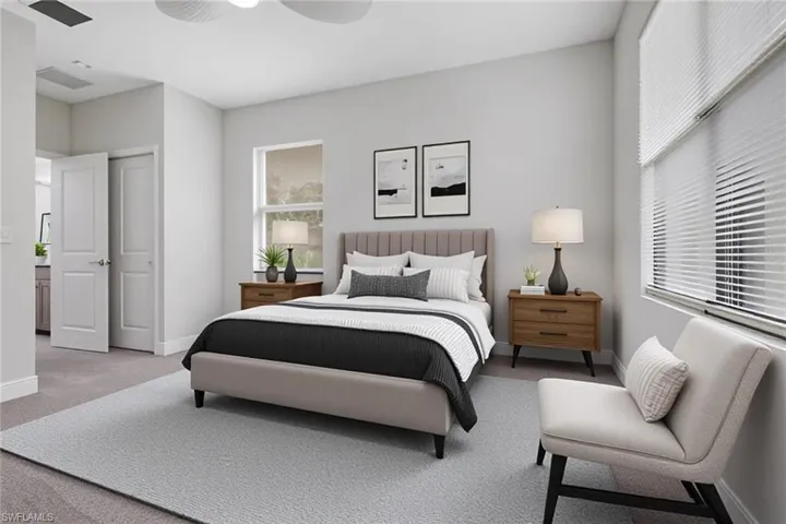 Carpeted bedroom with ensuite bathroom and ceiling fan