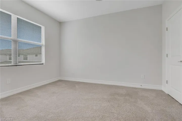 Unfurnished room featuring light colored carpet and baseboards