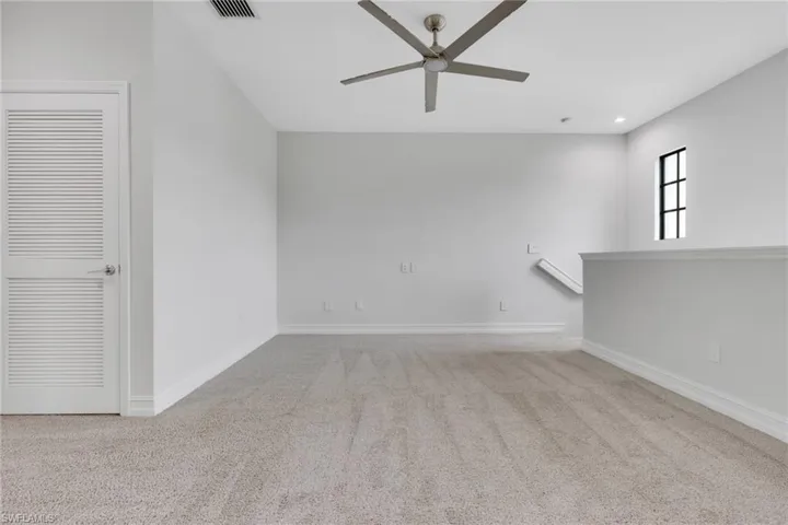 Empty room with light colored carpet, ceiling fan, and recessed lighting