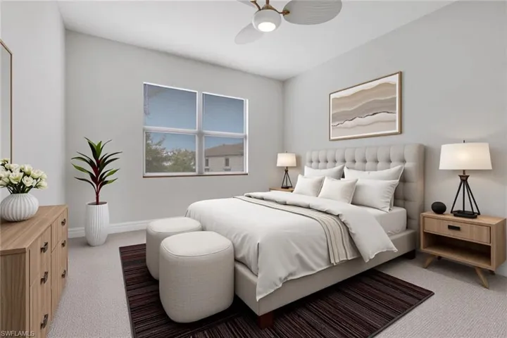 Carpeted bedroom with ceiling fan and baseboards