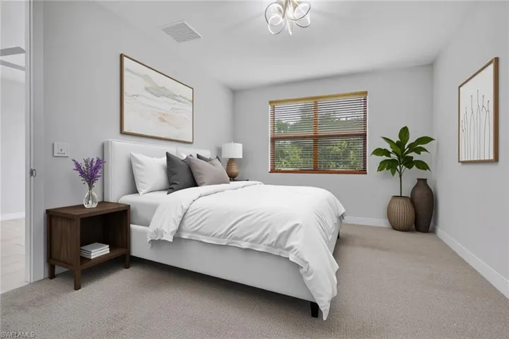 Bedroom featuring light carpet and baseboards