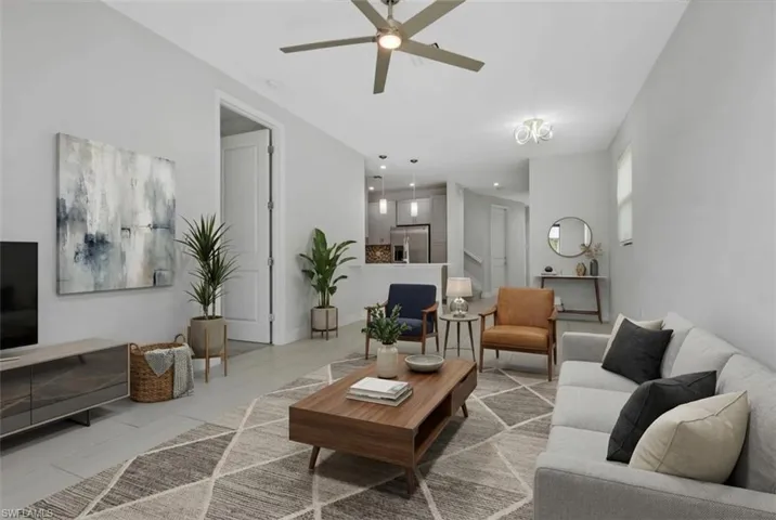Living area with ceiling fan and light tile patterned floors