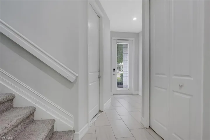 Foyer entrance featuring stairway and light tile patterned flooring