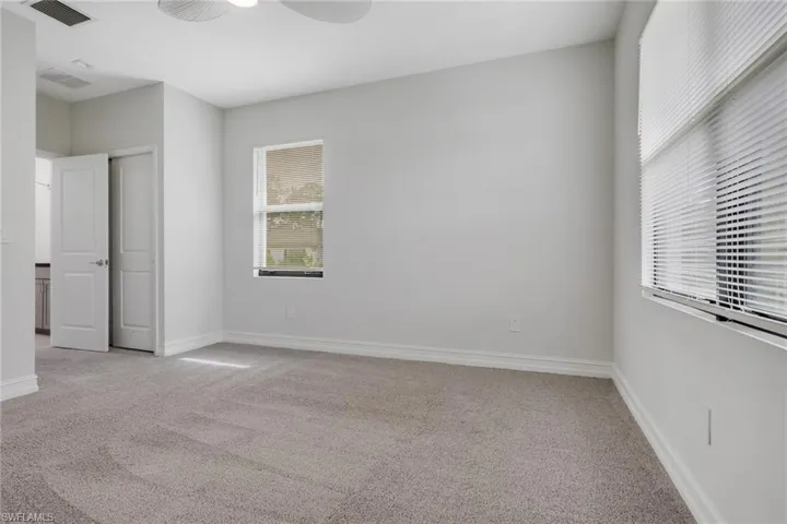 Unfurnished bedroom featuring light colored carpet, ceiling fan, and a closet